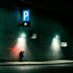 A person stands under neon lights by a concrete wall in Vancouver, BC, with a futuristic feel.